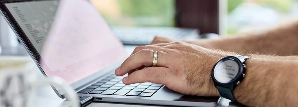 what is phishing? a close up of a laptop with a team member typing on the keyboard