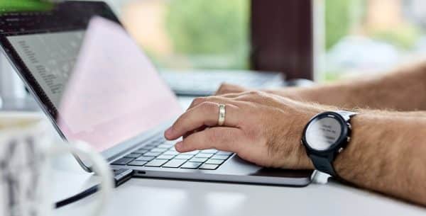 what is phishing? a close up of a laptop with a team member typing on the keyboard