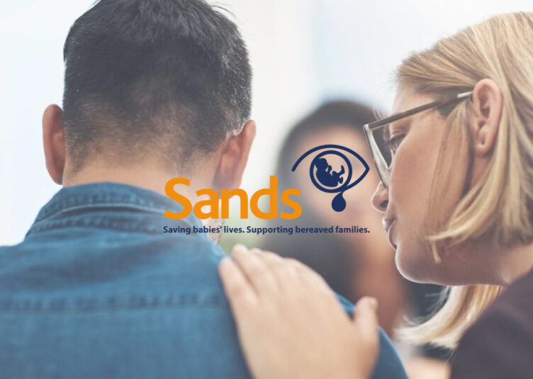 a woman consoling a man in a group setting, Sands logo overlayed in the centre of the image. IT Support for Non-Profits.