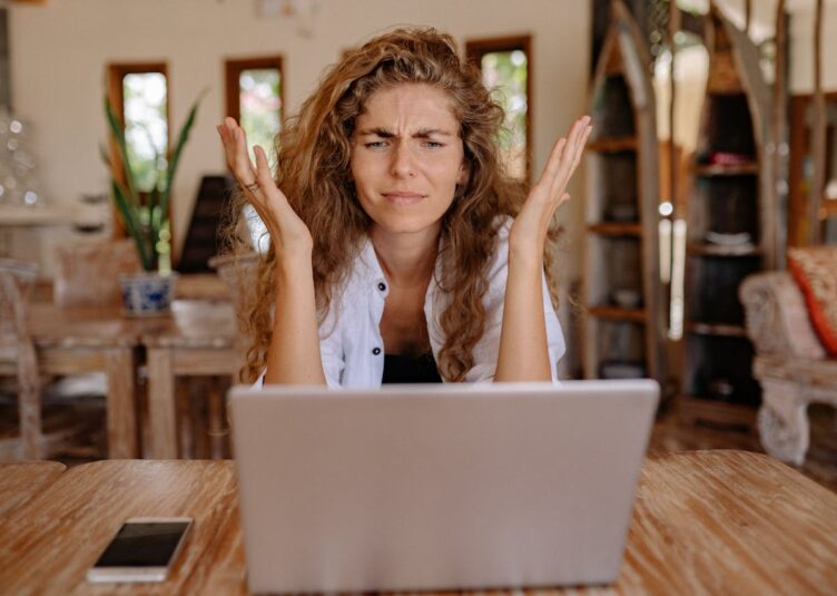 5 Signs You Need A New IT Provider signs you need to switch IT provider. a team member with hands near their head in frustration sitting in front of their laptop.