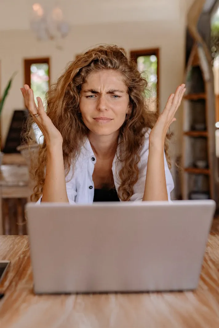 signs you need to switch IT provider. a team member with hands near their head in frustration sitting in front of their laptop.