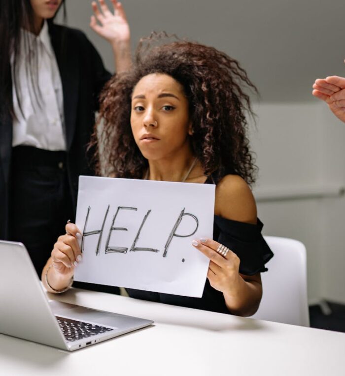 5 Signs You Need A New IT Provider a woman holding up a paper sign 'help' feeling helpless and lost due to not having a clear IT strategy
