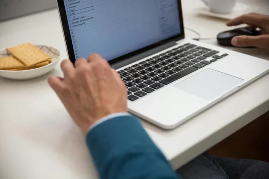 AI for Business - The Risks, Benefits And How to Stay Protected a worker on a laptop using excel. benefits of ai